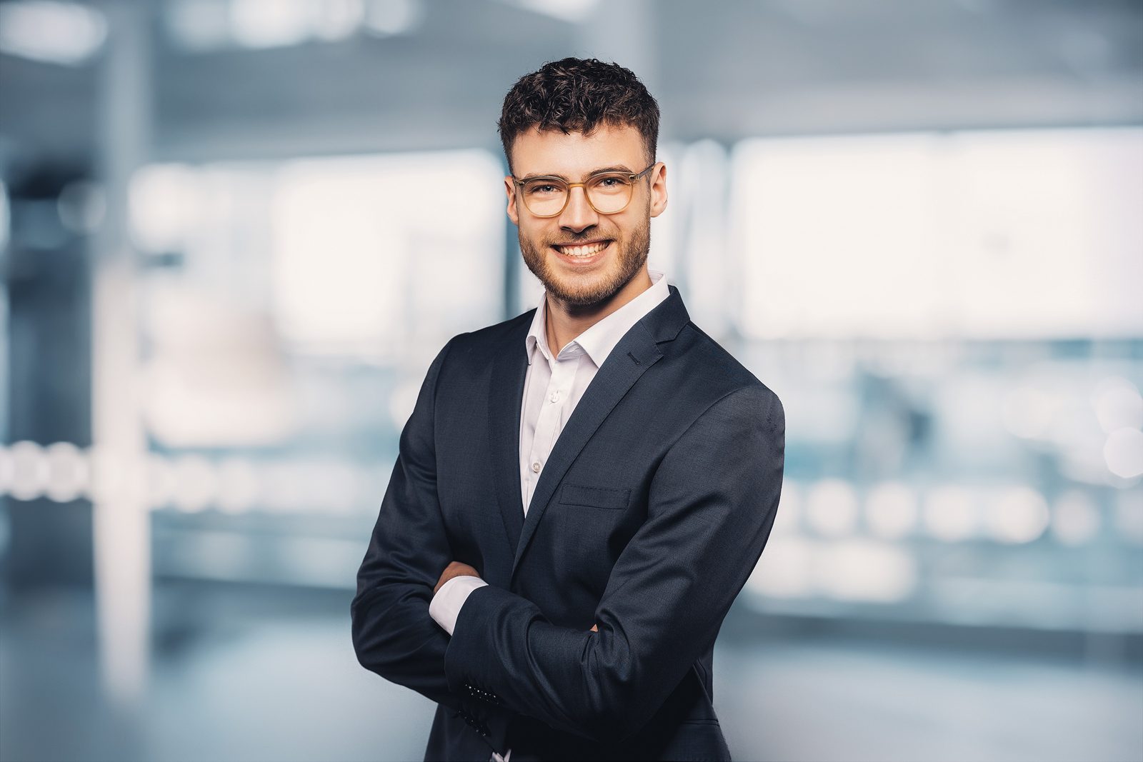 Bewerbungsfoto eines jungen Mannes mit Brille im Sakko