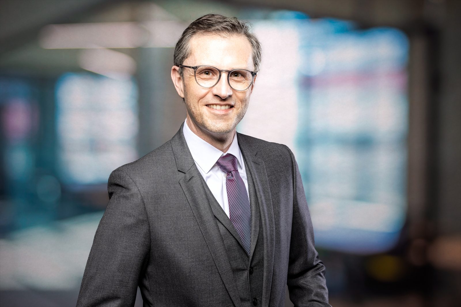 Bewerbungsfoto eines Mannes mit Brille und Krawatte
