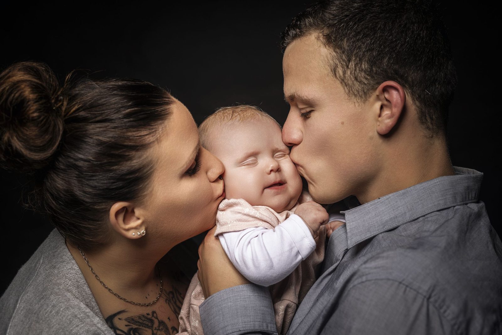 Eltern küssen ihr Baby auf die Wangen