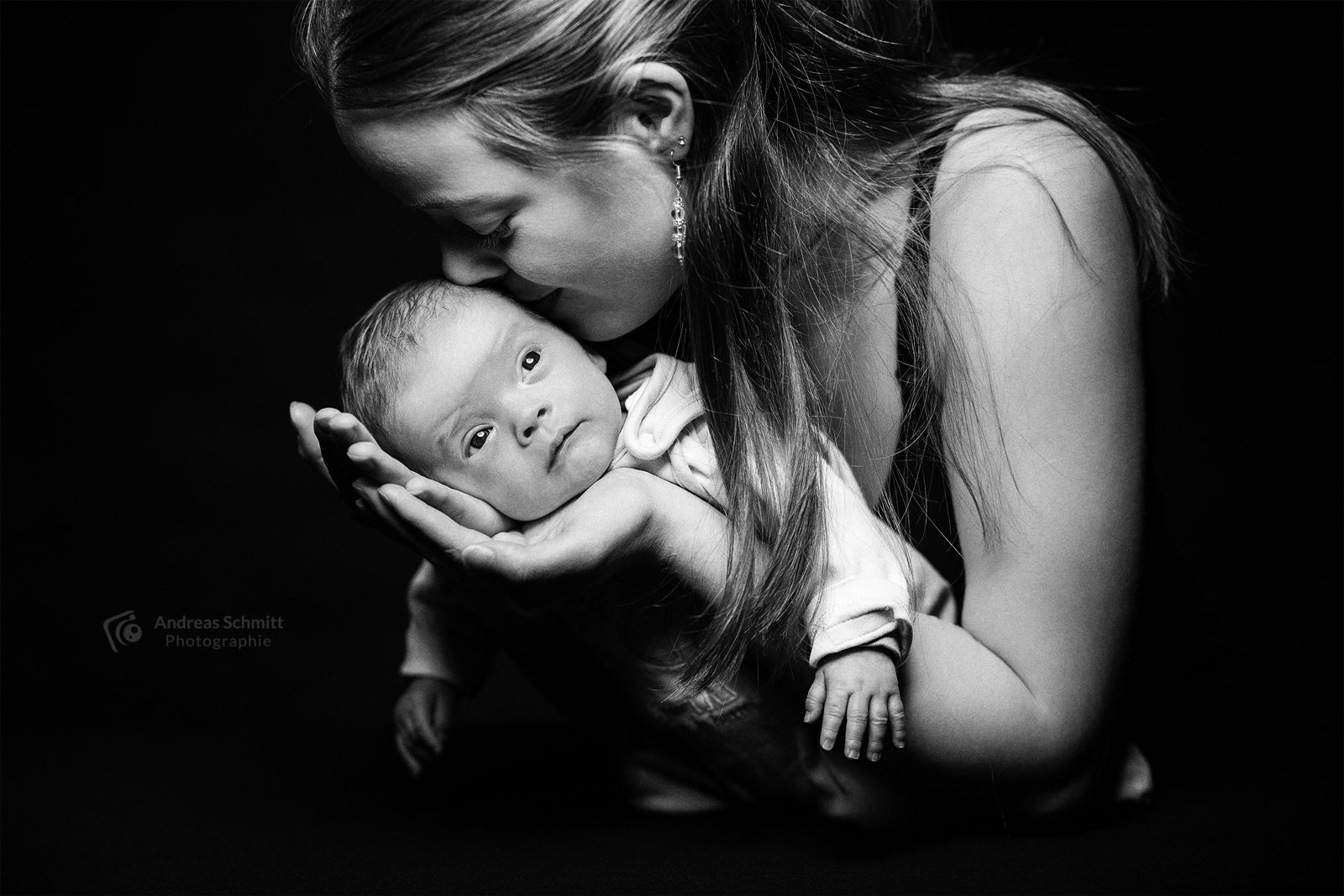 Mutter küsst ihr neugeborenes Baby, schwarz-weiß