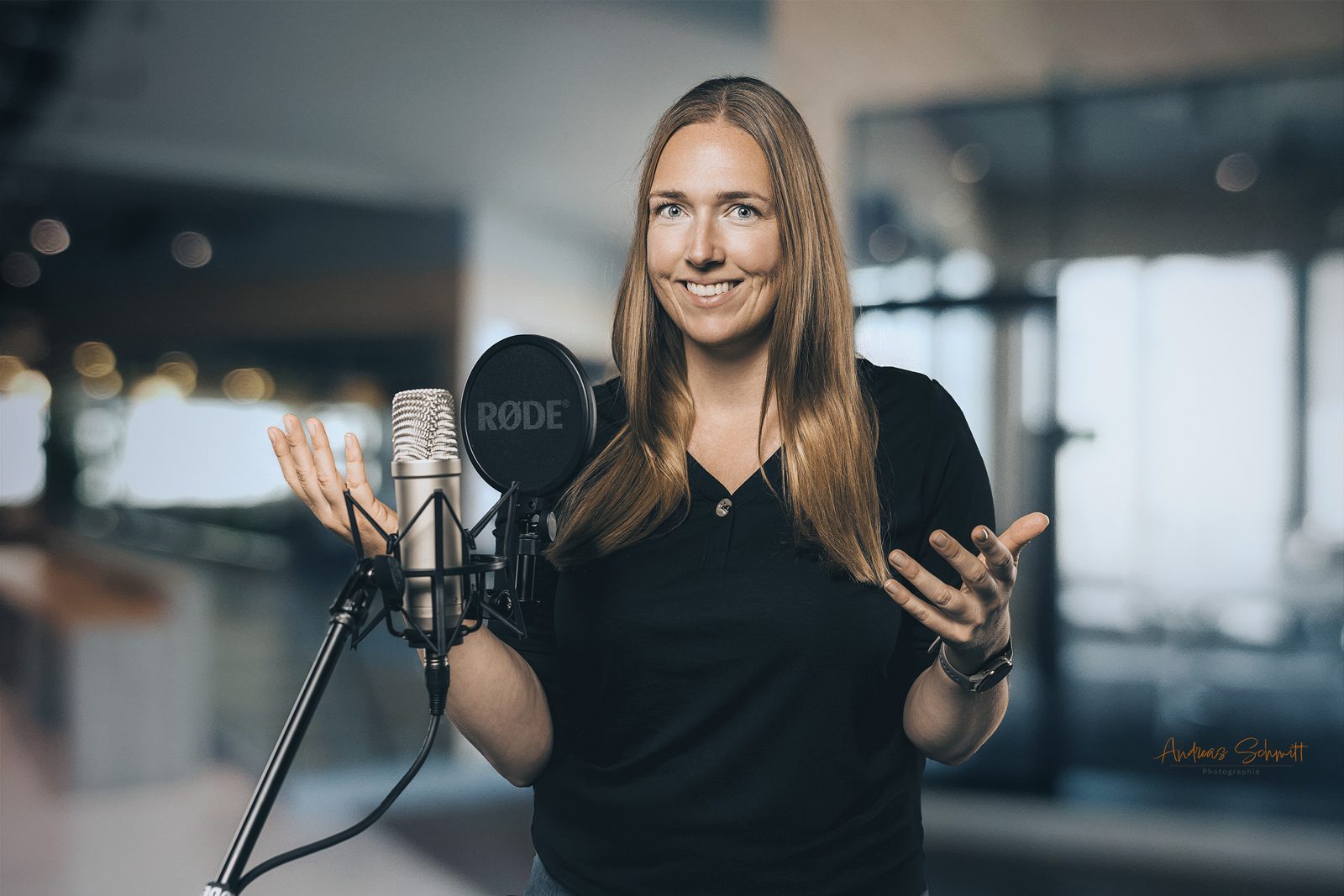 Frau spricht im Podcast-Studio in ein Mikrofon