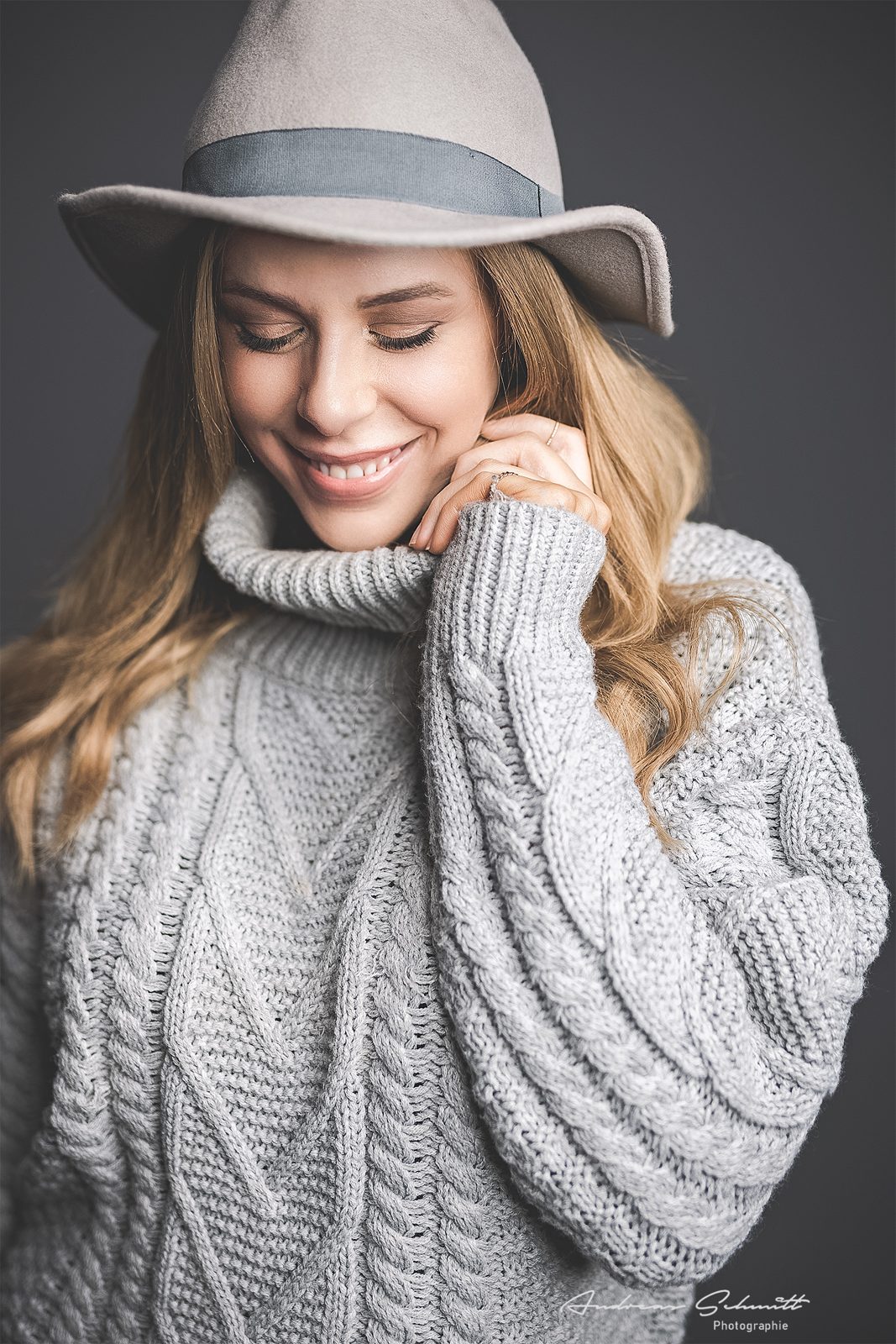 Portrait einer Frau mit Hut und grobem Strickpullover