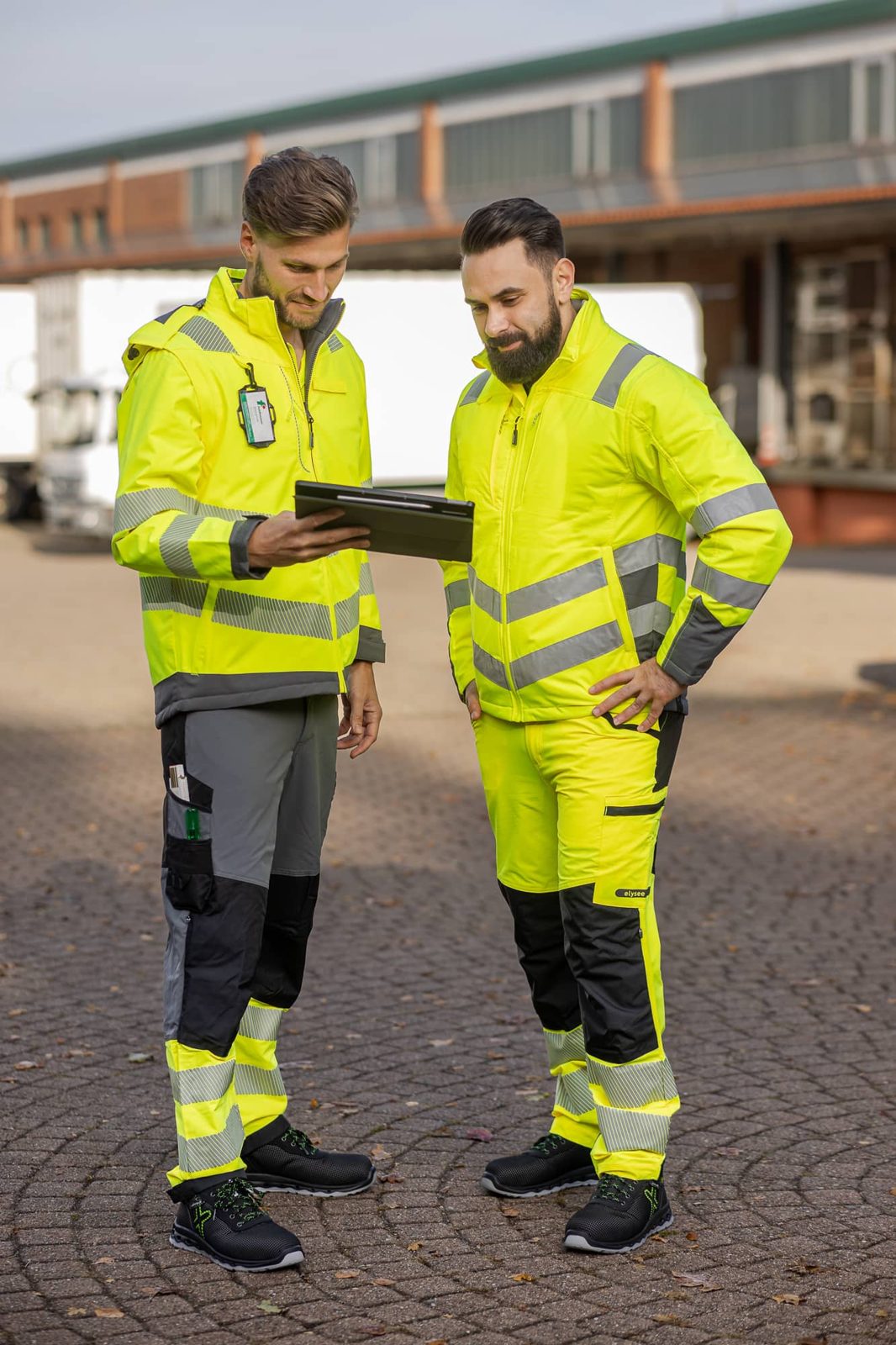 Zwei Mitarbeiter in Warnschutzkleidung besprechen einen Plan